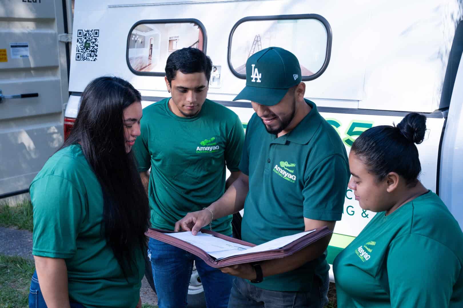 Amaya G Painting crew reviewing project plans beside the company van