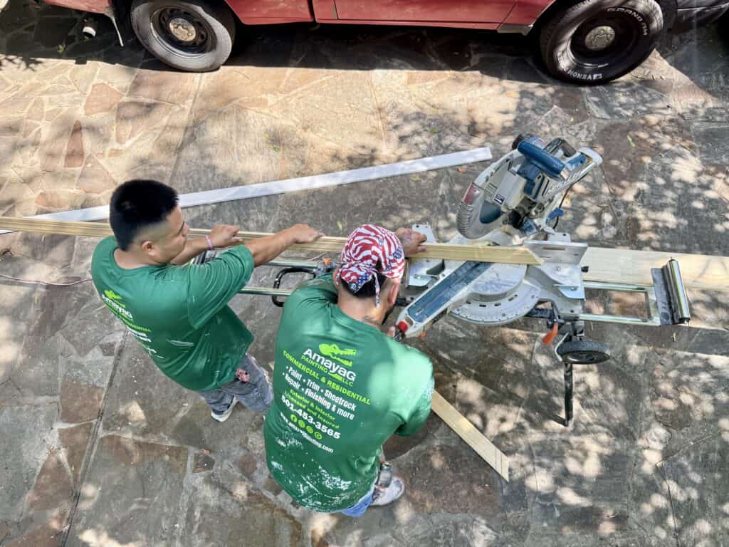 Amaya G Painting crew cutting finish trim on a miter saw