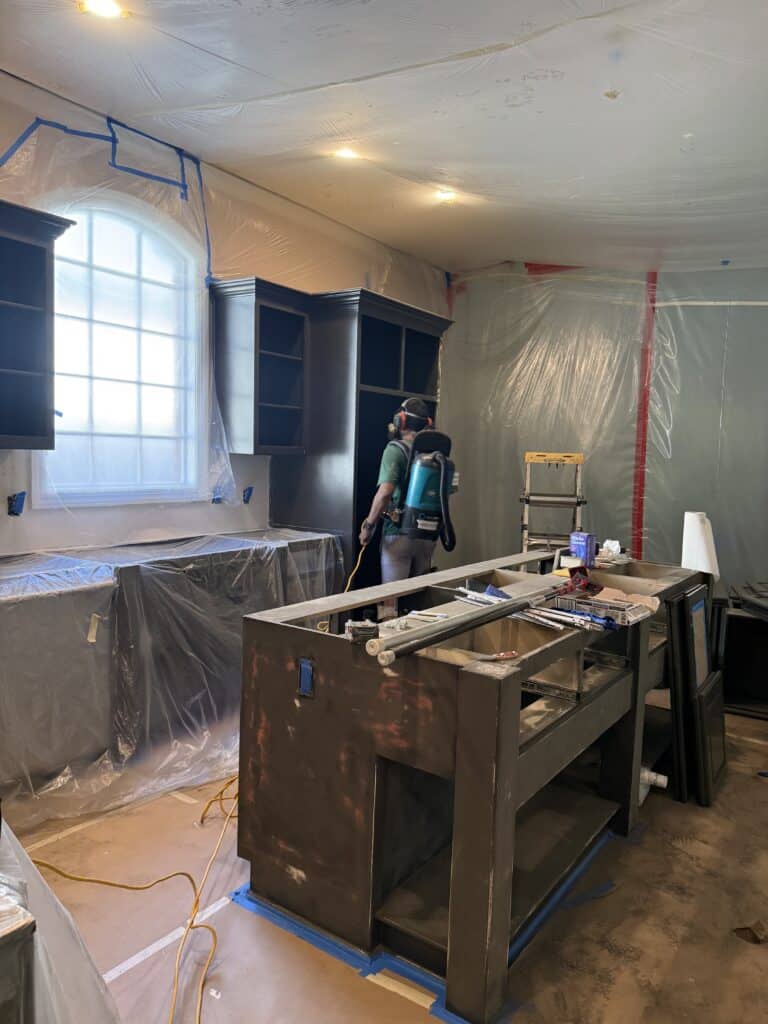 Kitchen island being sprayed during a cabinet refinishing project