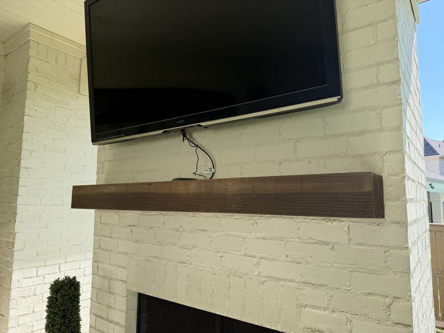 White painted brick fireplace with a reclaimed wood mantel after refinishing