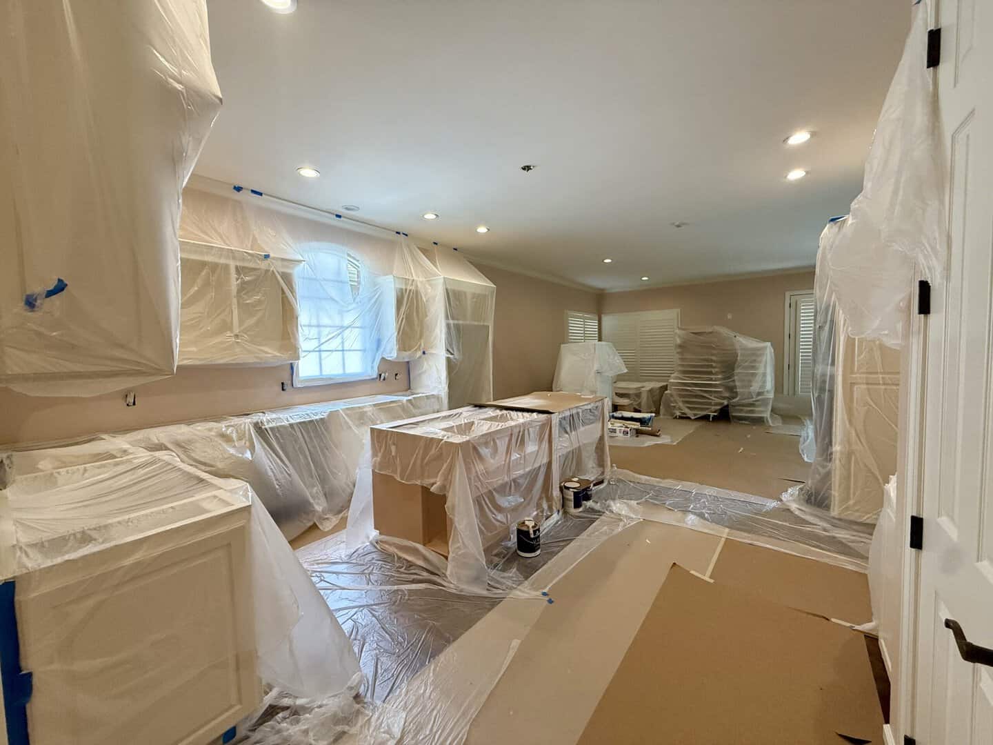 Large room fully masked and protected before spraying