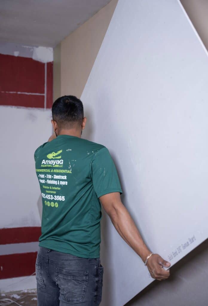 Amaya G Painting technician smoothing a wall before painting