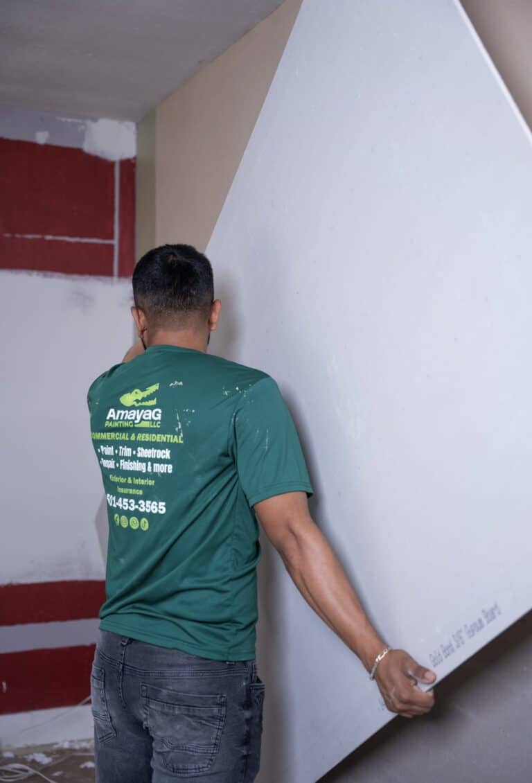 Amaya G Painting technician smoothing a wall before painting